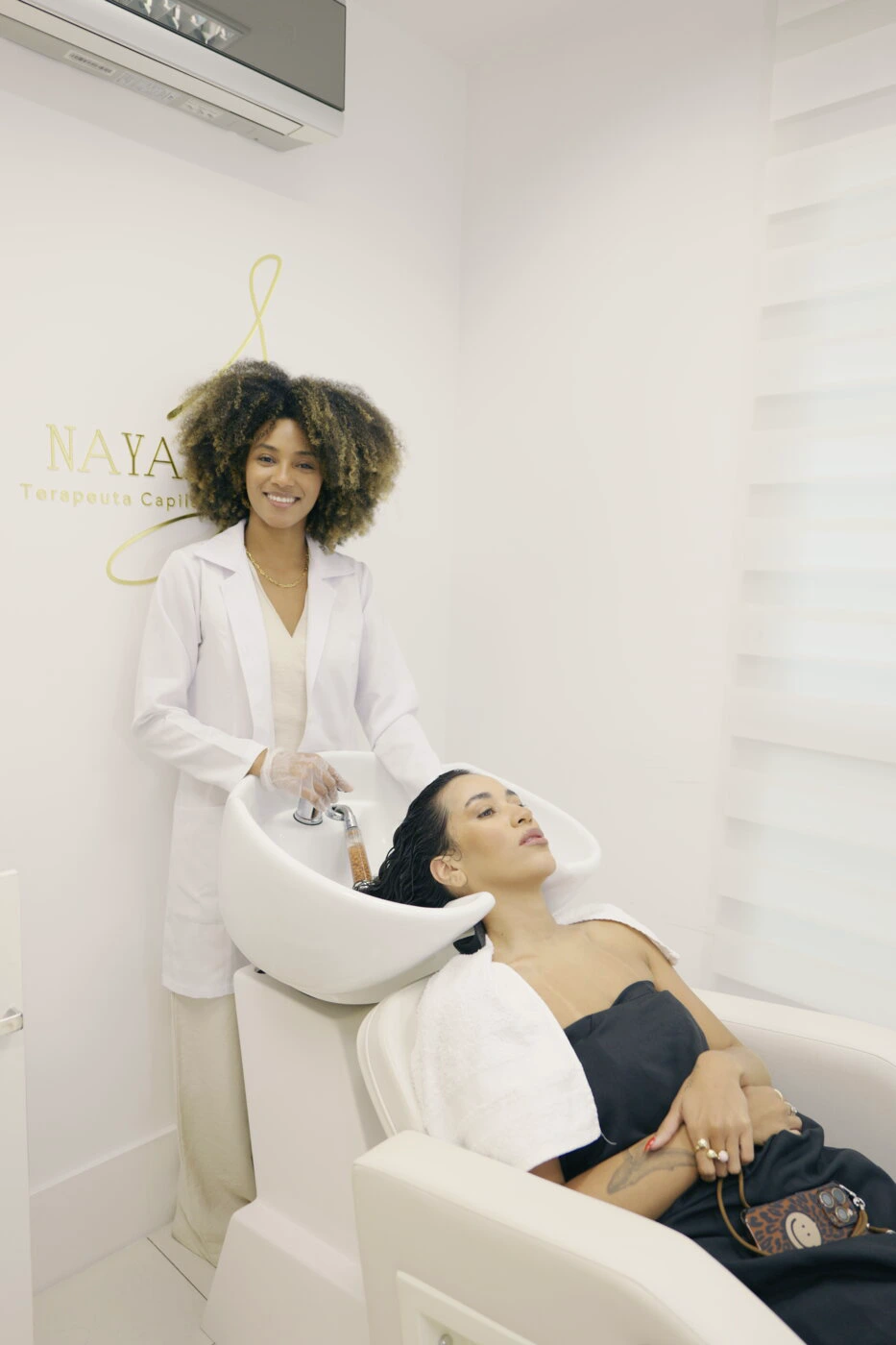 Nayara Santos acompanhando uma cliente no lavatório